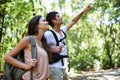 Happy couple, backpack and pointing with direction for sightseeing, destination or hiking together in nature. Young man Royalty Free Stock Photo