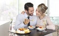 Happy couple at the bar with champagne and fruit cake, love Royalty Free Stock Photo