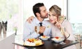 Happy couple at the bar with sparkling wine and cake