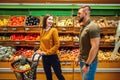 Happy couple with basket in grocery store Royalty Free Stock Photo