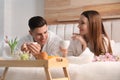 Happy couple in bathrobes having breakfast on bed Royalty Free Stock Photo