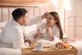 Happy couple in bathrobes having breakfast at home Royalty Free Stock Photo