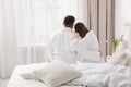 Happy couple in bathrobes sitting on bed Royalty Free Stock Photo