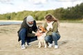 Happy couple with beagle dog on autumn beach