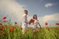 Happy couple breathing fresh air in a field with red poppy flowers, romantic date Royalty Free Stock Photo