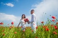 Happy couple breathing fresh air in a field with red poppy flowers, romantic date Royalty Free Stock Photo