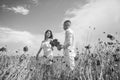 Happy couple breathing fresh air in a field with red poppy flowers, romantic date Royalty Free Stock Photo