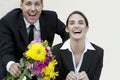 Happy couple in business suits with bouquet