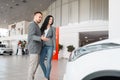 Happy couple buying new car in showroom Royalty Free Stock Photo