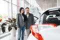 Happy couple buying new car in showroom Royalty Free Stock Photo