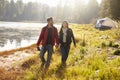 Happy couple on a camping trip walking near a lake