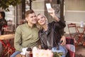 Happy couple capturing their date in the cafe Royalty Free Stock Photo