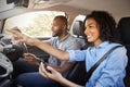 Happy couple in car on a road trip navigate with smartphone Royalty Free Stock Photo