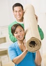 Happy Couple Carrying Carpet Roll Royalty Free Stock Photo