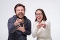 Happy couple caucasian mature man and woman laughing pointing on your joke