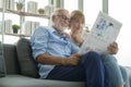 Happy Couple Caucasian senior are relaxing , reading newspaper in living room Royalty Free Stock Photo