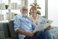 Happy Couple Caucasian senior are relaxing , reading newspaper in living room Royalty Free Stock Photo