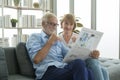 Happy Couple Caucasian senior are relaxing , reading newspaper in living room Royalty Free Stock Photo