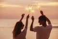 Happy couple celebrates sunset with sparklers Royalty Free Stock Photo