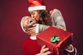 Happy couple celebrating Christmas time sharing gift box - Young lovers having fun during xmas holidays Royalty Free Stock Photo