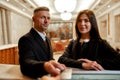 Take it. Happy couple checking in hotel at reception desk. Man is giving his credit card to pay for a hotel room Royalty Free Stock Photo