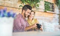 Happy couple checking photos on mirrorless camera during holidays - Young people having fun during travel vacation shooting photos Royalty Free Stock Photo