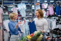 Happy couple choose infant clothes in the shopping center. Royalty Free Stock Photo