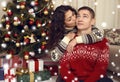 Happy couple kiss in christmas decoration at home. New year eve, ornated fir tree. Winter holiday and love concept. Royalty Free Stock Photo