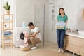 Happy couple with clothes in bathroom. Laundry day Royalty Free Stock Photo