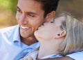 Happy couple, closeup and kiss in nature for embrace, love or support in relax for outdoor bonding. Young woman kissing Royalty Free Stock Photo