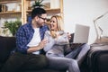 Couple communicating while using credit card and laptop for online shopping at home