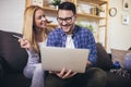 Couple communicating while using credit card and laptop for online shopping at home Royalty Free Stock Photo