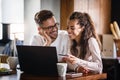 Happy couple communicating while using credit card and laptop for online shopping at home Royalty Free Stock Photo