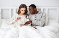 Happy couple with computer tablet and smartphone on winter morning in bed Royalty Free Stock Photo