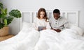 Happy couple with computer tablet and smartphone on winter morning in bed Royalty Free Stock Photo