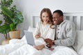 Happy couple with computer on winter morning in bed Royalty Free Stock Photo