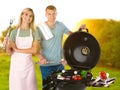 Happy couple cooking on barbecue grill. Picnic time