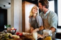 Happy couple cooking together. Husband and wife in their kitchen at home preparing healthy food