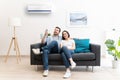 Happy couple cool down using air conditioning at home Royalty Free Stock Photo