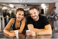 Happy couple with cups of coffee resting in a fitness club Royalty Free Stock Photo