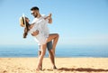 Happy couple dancing on beach near sea. Honeymoon trip Royalty Free Stock Photo