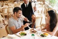 Happy couple, date and dining with kebab of waiter serving, meat or slices on romantic dinner at table. Young man or Royalty Free Stock Photo