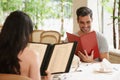 Happy couple, date and reading menu at restaurant for fine dining, romance or ordering food together. Young man and Royalty Free Stock Photo