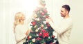 Happy couple decorating christmas tree at home Royalty Free Stock Photo