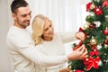 Happy couple decorating christmas tree at home Royalty Free Stock Photo