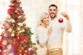 Happy couple decorating christmas tree at home Royalty Free Stock Photo
