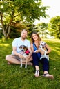 Happy couple of dog lovers sitting with their pets Royalty Free Stock Photo