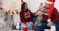 Happy couple with dog sitting on the sofa near Christmas tree Royalty Free Stock Photo