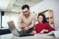 Couple doing business together working at small office on the laptop. They are using credit card for online shopping Royalty Free Stock Photo