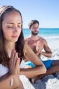 Happy couple doing yoga beside the water Royalty Free Stock Photo